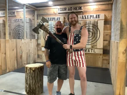A league thrower at Axe Play in Hudson, NH, proudly posing with a large axe target prize