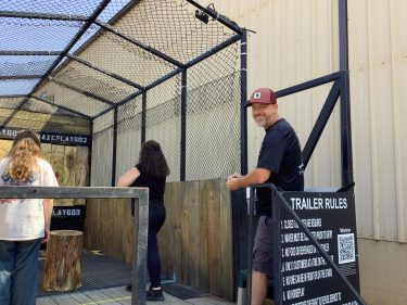 Ryan, axe throwing coach at Axe Play in Hudson NH, smiling while instructing guests