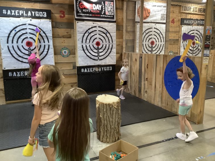 Young girls throwing foam axes at Velcro targets during kids party Nashua NH