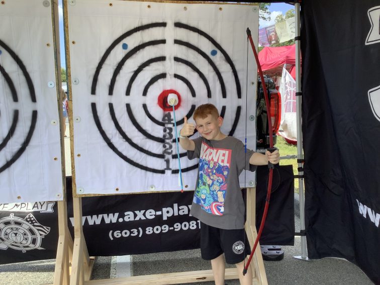Boy hitting bullseye with Velcro arrow at Axe Play kids party Nashua NH