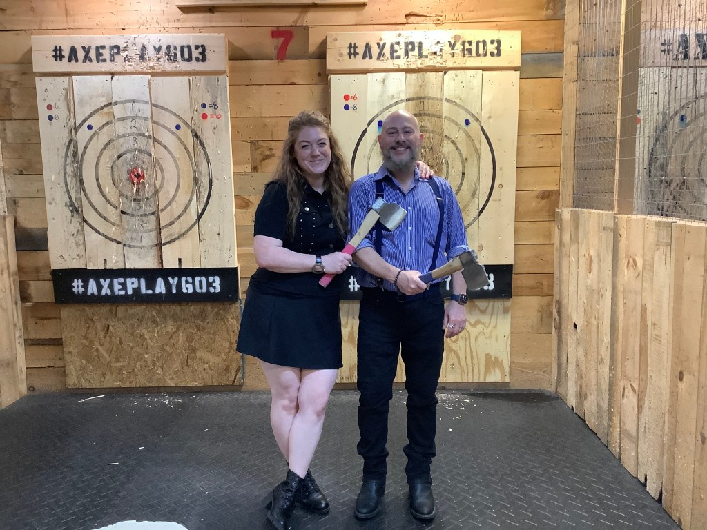 Two people posing after a friendly round of axe throwing at Axe Play Hudson NH – a unique date night idea near Nashua NH.