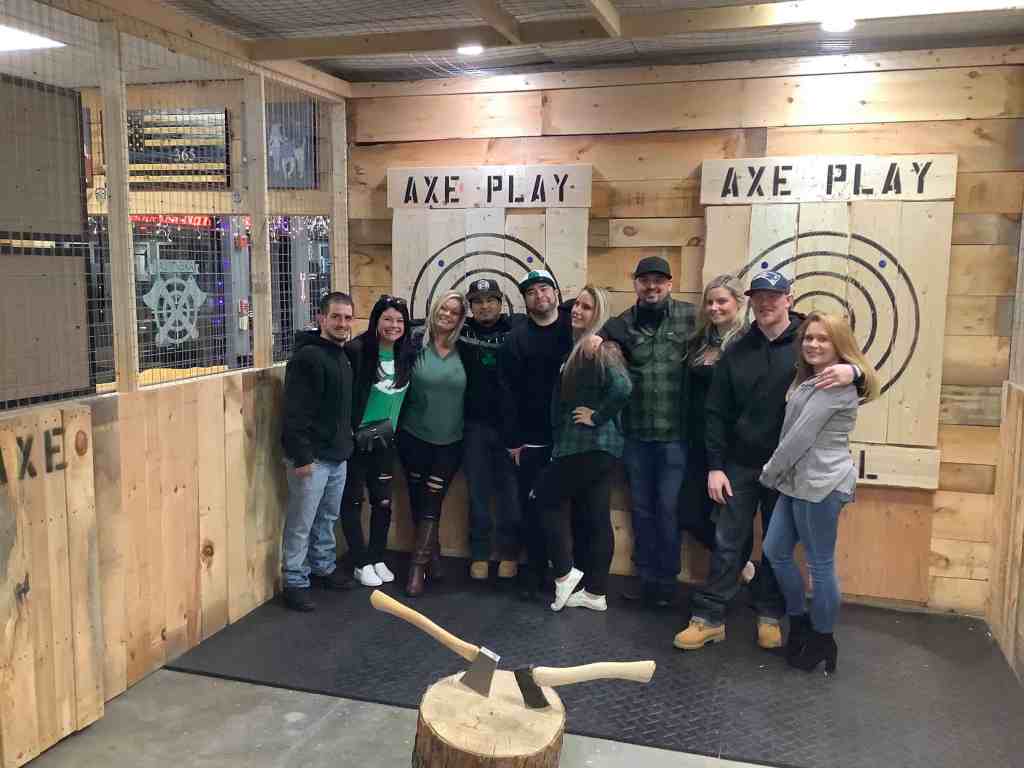 Group of friends posing at Axe Play axe throwing venue in Hudson NH