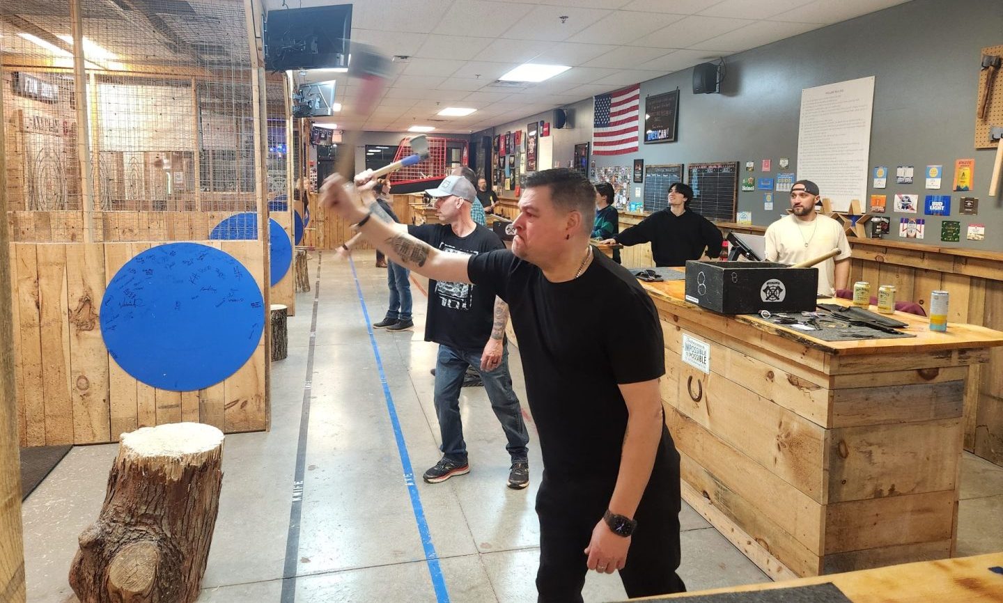 Axe throwing action shot showing proper throwing technique at Axe Play in New Hampshire