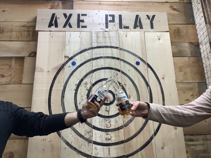 Friends celebrating after hitting a bullseye at Axe Play axe throwing in Hudson NH near Nashua and Lowell