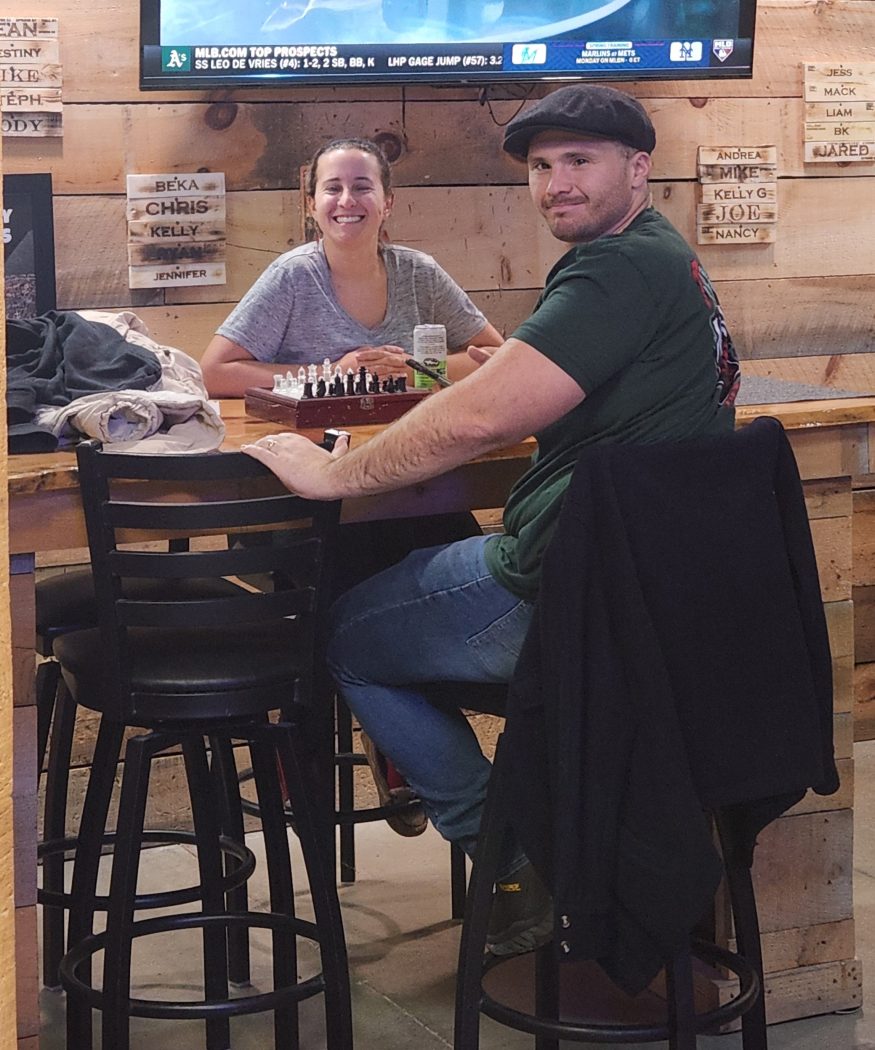 Couple relaxing with drinks during axe throwing date night at Axe Play NH