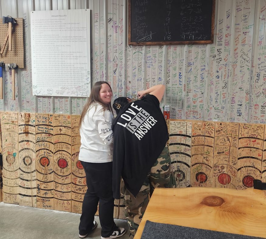 Couple laughing and taking photos during axe throwing date night at Axe Play NH