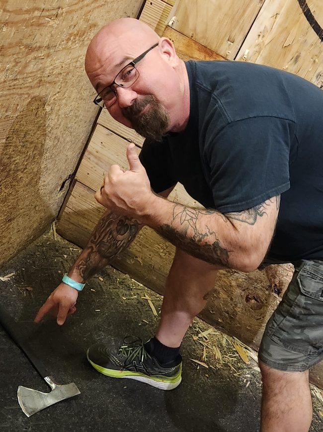 Man pointing at missed axe throw at Blade and Timber Honolulu axe throwing lanes