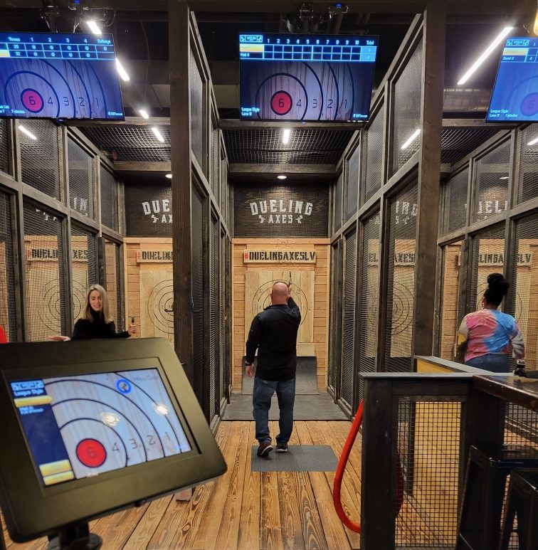 Man throwing an axe at Dueling Axes Las Vegas during a session