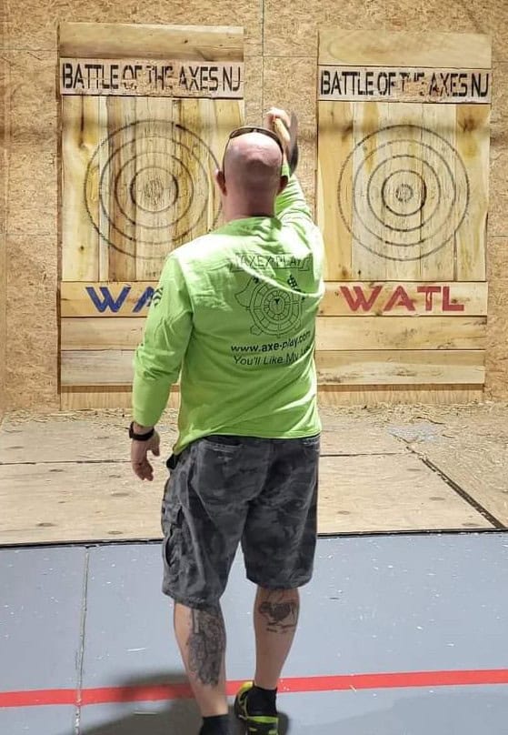 Man throwing an axe during a tournament at NJ Axe House
