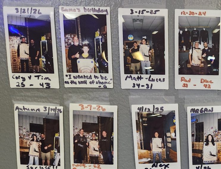 Axepert Challenge wall of shame at Axe Play showing polaroid photos of players who took on the axe throwing challenge