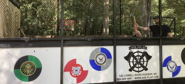 A real guest mid-throw inside Axe Play’s mobile trailer during a live private event, showing authentic engagement and energy.