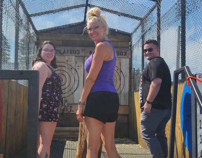 Guest throwing an axe inside mobile axe throwing trailer at private event