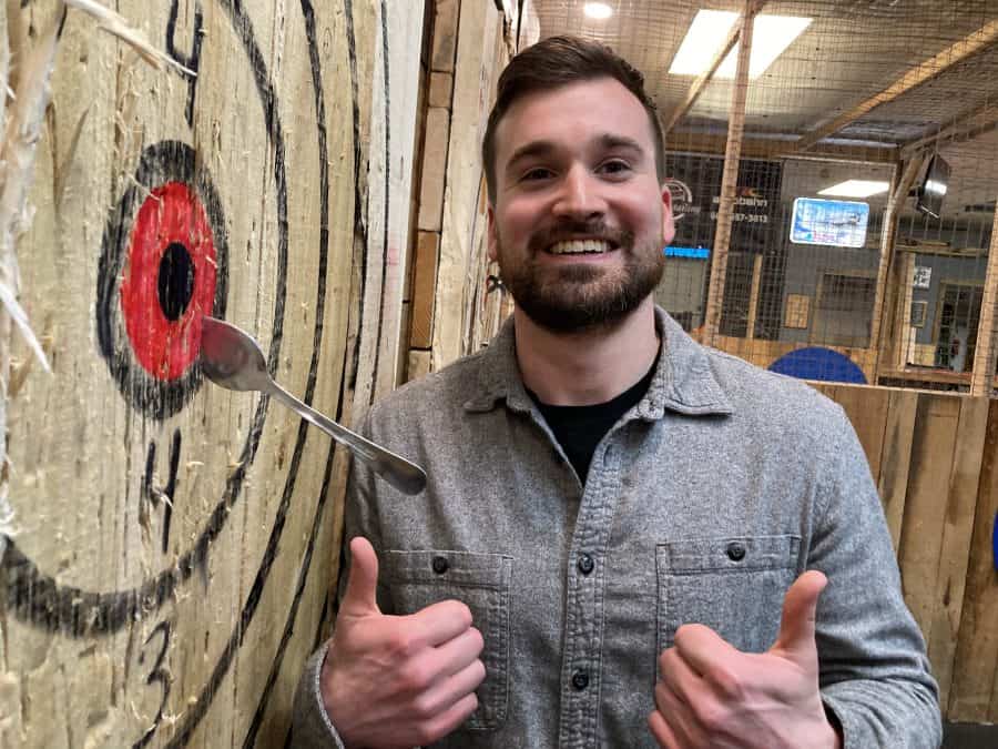 Man hitting a bullseye with a spoon at Axe Play in Southern NH