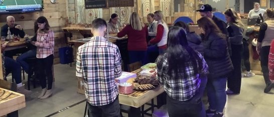 Corporate team enjoying axe throwing, food, and social time at Axe Play in Hudson NH