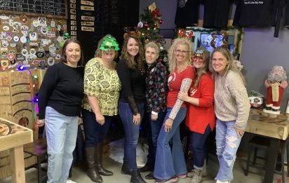 Group of coworkers posing together during a Christmas holiday party at Axe Play.