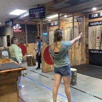 Friends using Axe Play gift card for axe throwing in Hudson NH